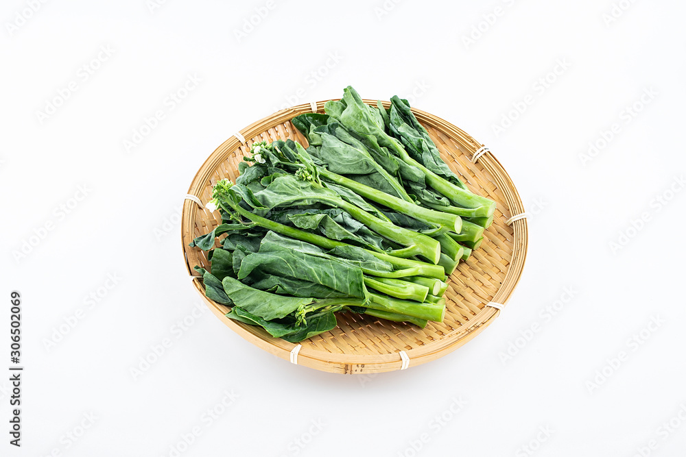 Bamboo sieve filled with fresh green vegetables kale hearts on white background Bamboo sieve filled with fresh green vegetables kale hearts on white background