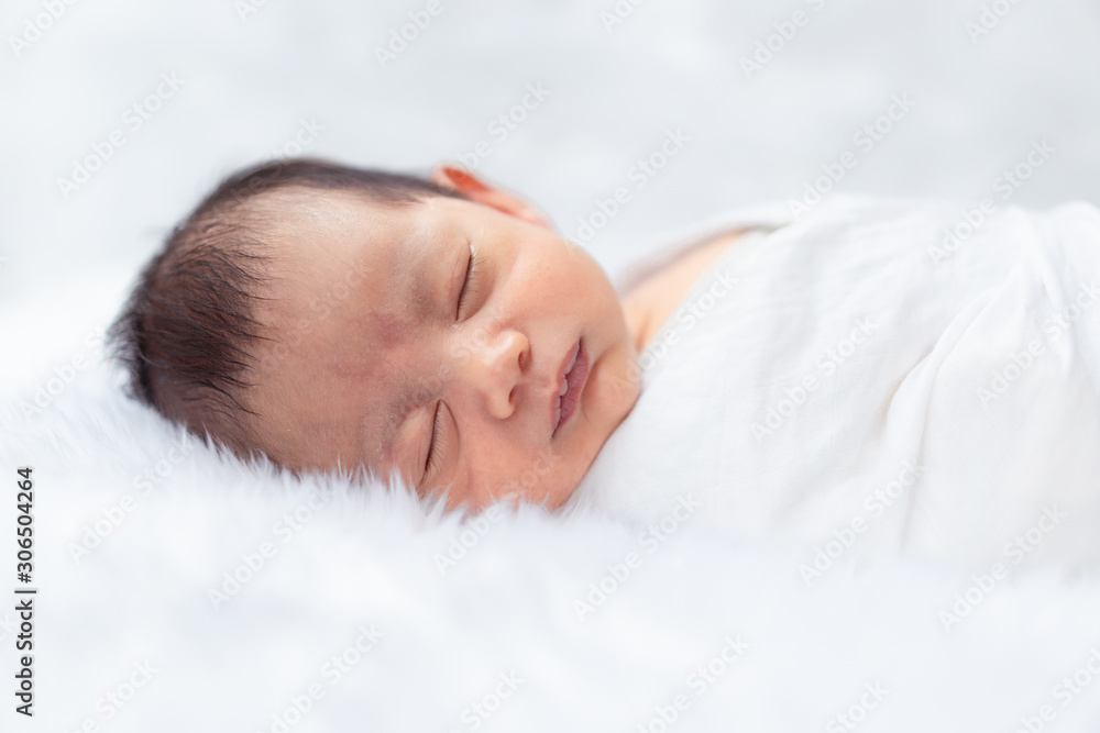 A cute infant baby is peaceful sleep on the bed.
