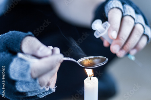 Schilderij op canvas Closeup male hands in black fingerless gloves are preparing dose of heroin for injection