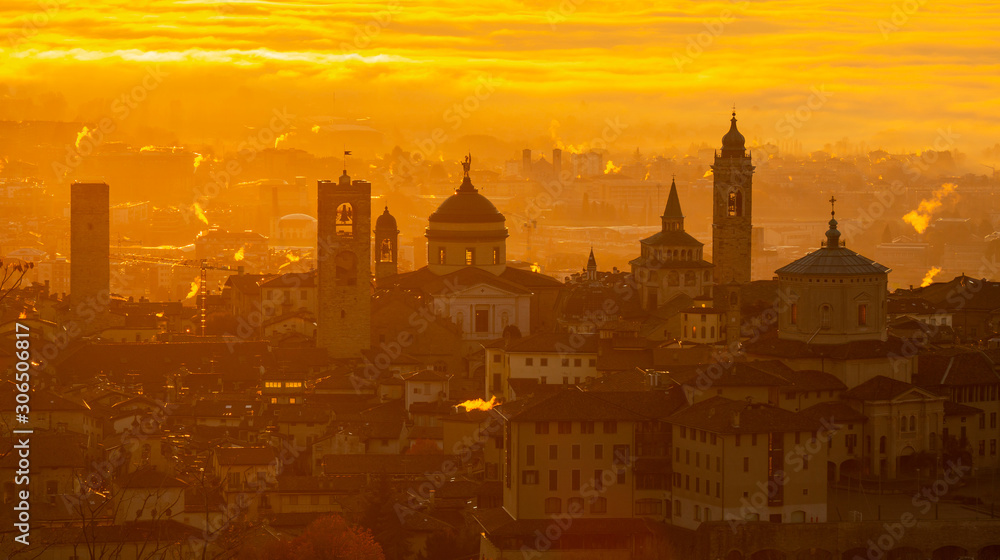 Bergamo, one of the most beautiful city in Italy. Amazing landscape at the old town during the sunrise. The fog covers the plain around the town. Fall season. Warm colors contest Bergamo, one of the most beautiful city in Italy. Amazing landscape at the old town during the sunrise. The fog covers the plain around the town. Fall season. Warm colors contest