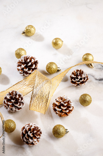Festive christmas ornaments on white table and gold ribbon
