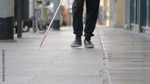 blind man walking on sidewalk in the city. autonomy,handicap photo