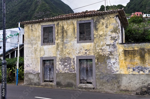 Abandoned yellow building in front of an asphalted road (Seixal, madeira, Portugal)