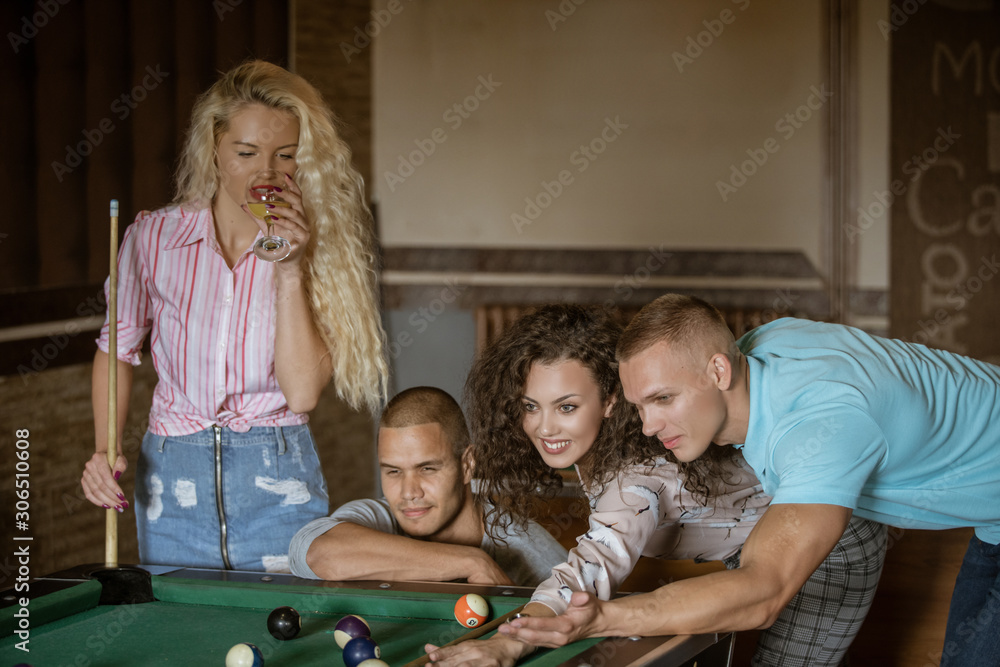 Obraz premium Young people playing snooker at bar