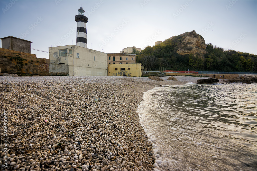 Εκτύπωση καμβά The Faro di Ortona and its pebble beach at sunset