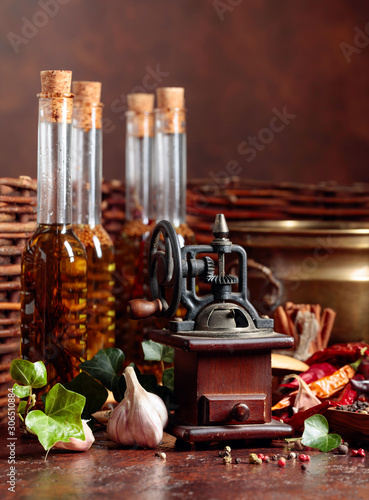 Various vintage cooking utensils with spices, seasonings and bottles of olive oil.