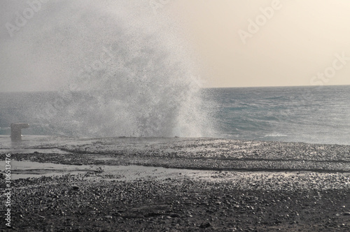 Waves of Aegean sea break about pier coast of the Crete
