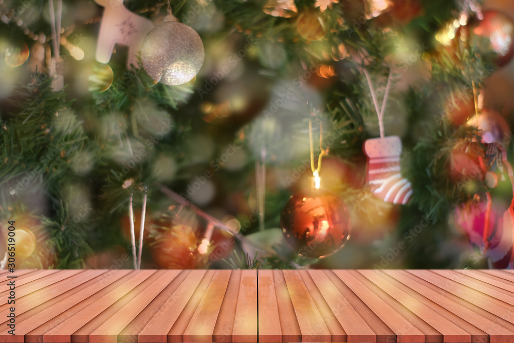 Wood table top on blurred colorful Christmas tree and bokeh background, for display or montage products.