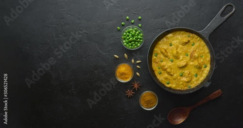 Cinemagraph loop. Cooking tasty chicken curry in pan with spices. Flat lay, top view with copy space photo