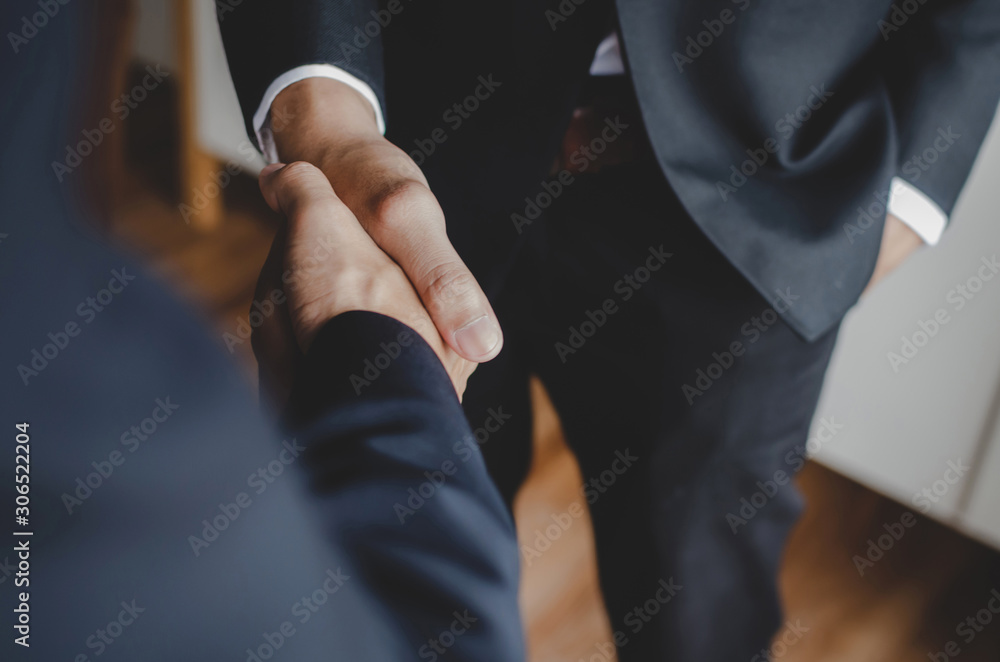 Partnership. two business people standing and shaking hand after business signing contract in meeting room at office, job interview, success, negotiation, partnership, teamwork, financial concept