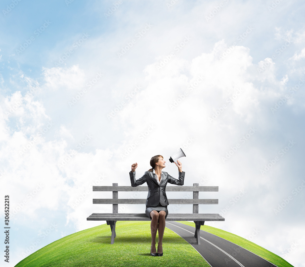 Business woman with megaphone on wooden bench Business woman with megaphone on wooden bench