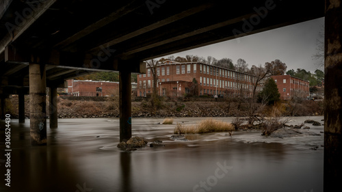 Industrial building framed by bridge spanning Haw river © David