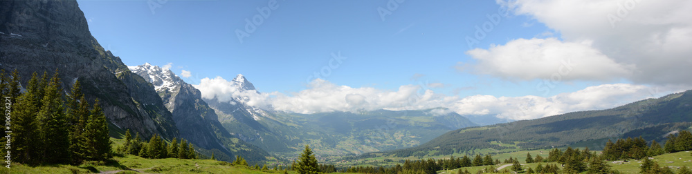 Beautiful Switzerland mountain panorama. Blue skies with clouds. Mountain peaks with snow. Wide image