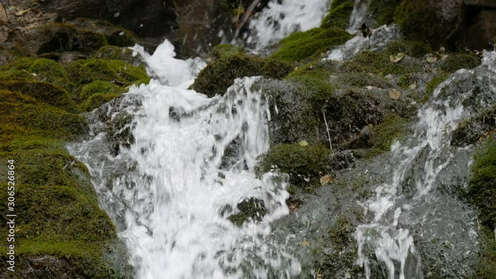 Green moss stones in the Carpathian mountains. Wonderful mountain waterfall cascade falls near large grey rocks Green moss stones in the Carpathian mountains. Wonderful mountain waterfall cascade falls near large grey rocks