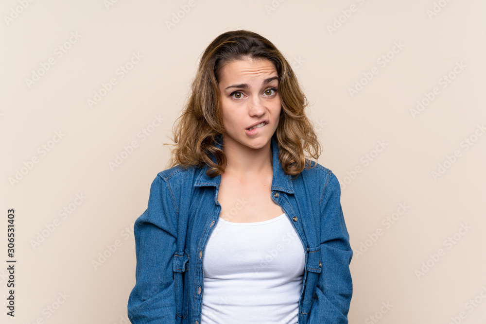 Obraz premium Young blonde woman over isolated background having doubts and with confuse face expression