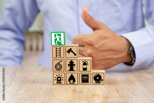 Photo Wooded blocks Stacking with fire escape icon for safety concept.