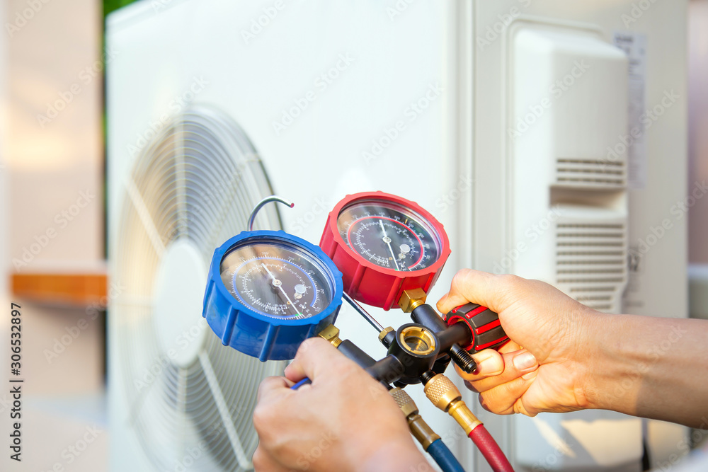 Hands of Technician are using a measuring tool to check Vacuum pump