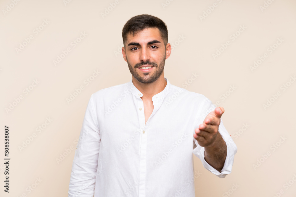 Handsome man with beard over isolated background handshaking after good deal Handsome man with beard over isolated background handshaking after good deal