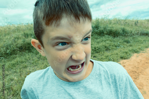 Fotografi Angry screaming teenage boy with open mouth close up, deviant behavior concept
