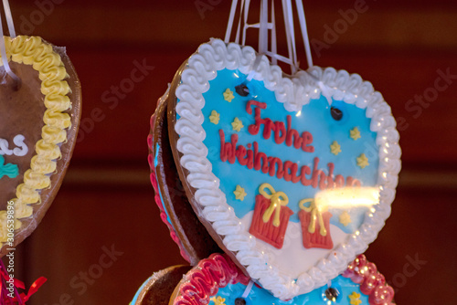 Weihnachtliche Lebkuchen auf einem Weihnachtsmarkt werden von Pfefferküchler mit buntem Zuckerguss als Lebkuchenherzen mit weihnachtlichen Motiven angeboten auf dem Christkindlemarkt im Advent photo