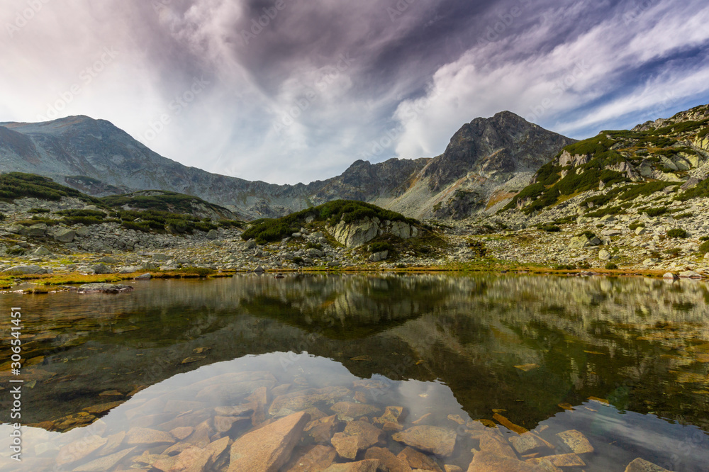 Marvelous glacier lake in the Romanian Alps, in summer, and dramatic storm clouds