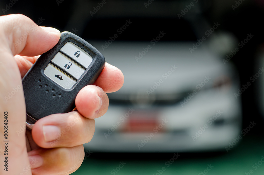 Car smart key is an electronic access and authorization system, Hand holding smart key of car. Car smart key is an electronic access and authorization system, Hand holding smart key of car.