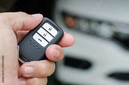 Car smart key is an electronic access and authorization system, Hand holding smart key of car.
