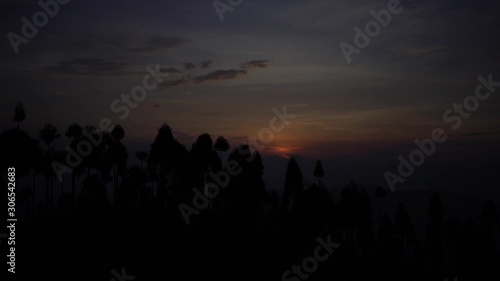 Morning timelapse of the sun rising as seen from Antu Danda, Illam, Nepal that receives the first sun-rise in Nepal. Wide Shot. photo
