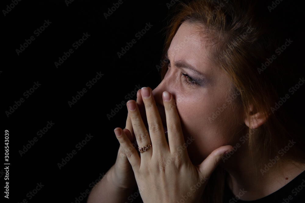 portrait of a young beautiful woman who blows her nose on a black background. portrait of a young beautiful woman who blows her nose on a black background.
