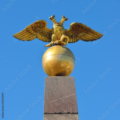 Two-headed Russian eagle. Golden architectural detail against blue sky.