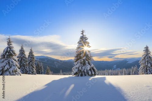 Amazing winter sunrise. Sun rays lighten up the sky and horizon. Landscape of high mountains. Winter scenery. Wallpaper background. Location place Carpathian, Ukraine, Europe.