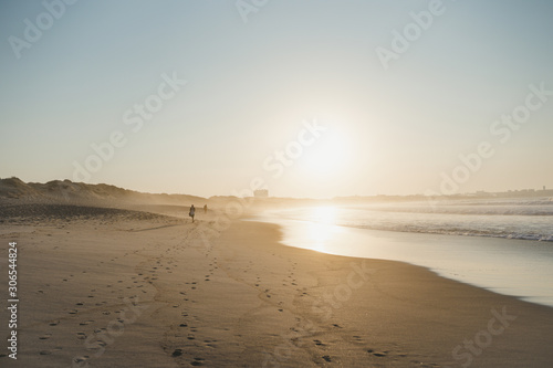 Sunset on the Atlantic ocean sandy beach with people Peniche Portugal
