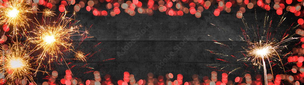 Silvester background banner panorama long- Frame made of red bokeh lights, sparklers firework on rustic wooden texture, top view with space for text - obrazy, fototapety, plakaty 