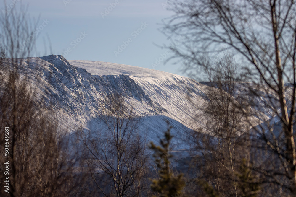 cliff face on entry into the Lairig Ghru in the cairngorms national park during winter in November during a clear blue sky day. 