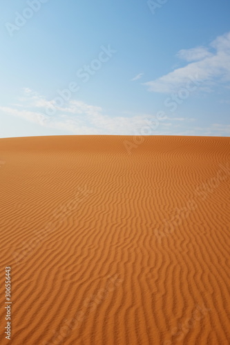 Bright orange rippled desert sand and blue sky in Riyadh, Saudi Arabia