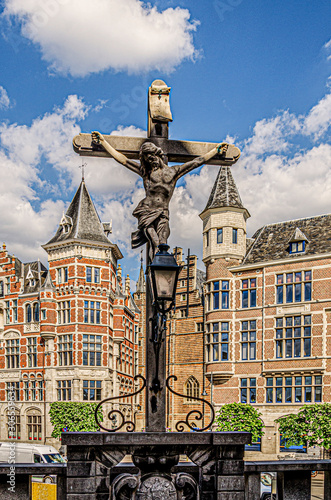 Cross in the foreground and background old buildings. Antwerp Belgium.