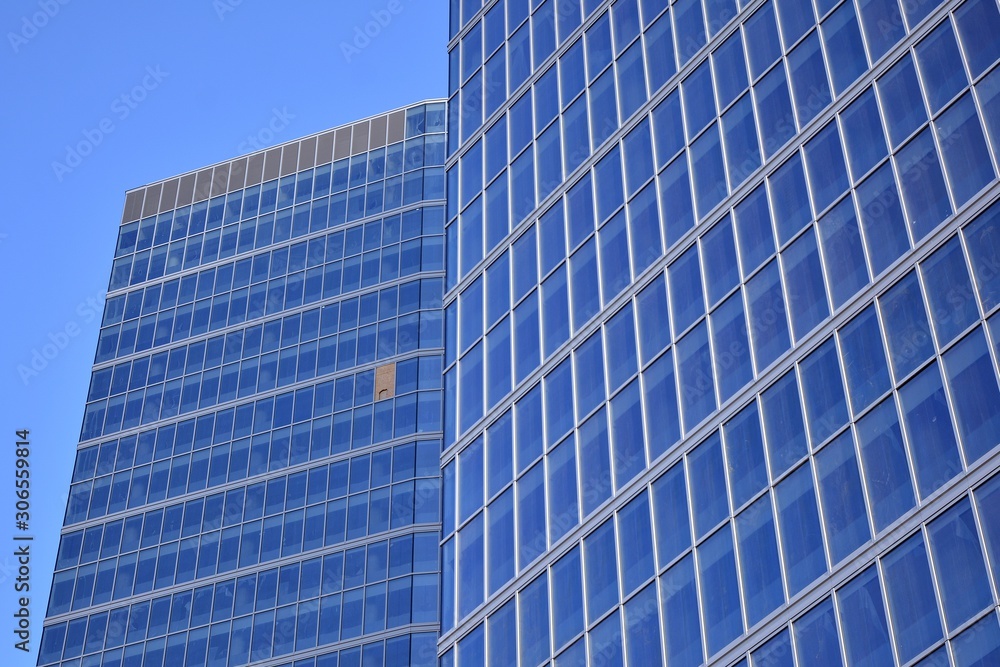 Fototapeta premium Abstract texture of blue glass modern building skyscrapers. Business background.