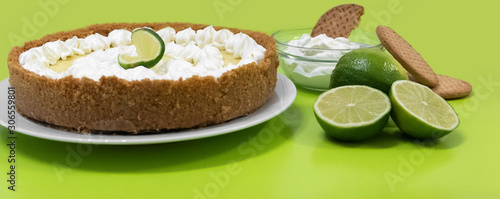 Key lime pie with cookies and lime on a green background photo