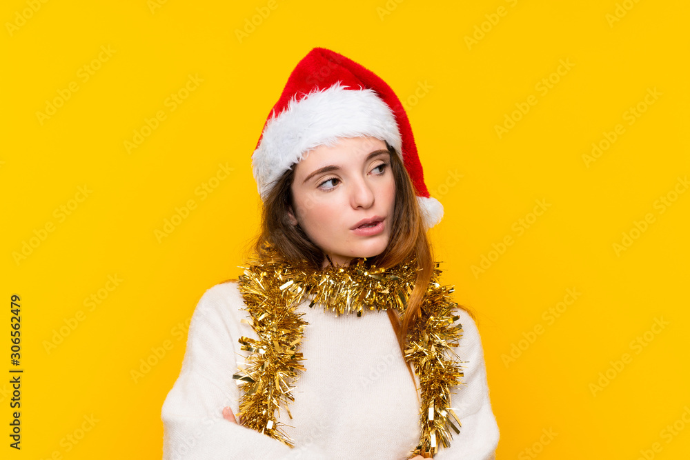 Girl with christmas hat over isolated yellow background thinking an idea Girl with christmas hat over isolated yellow background thinking an idea