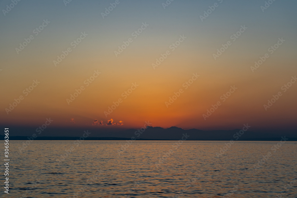 Sun is about to rise above clouds on sea horizon in Ioniean sea, view from Zakynthos island