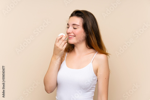 Young brunette girl with moisturizer over isolated background