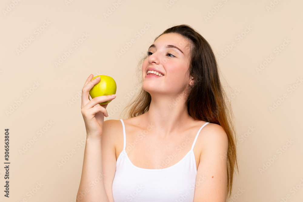 Young brunette girl with an apple over isolated background Young brunette girl with an apple over isolated background