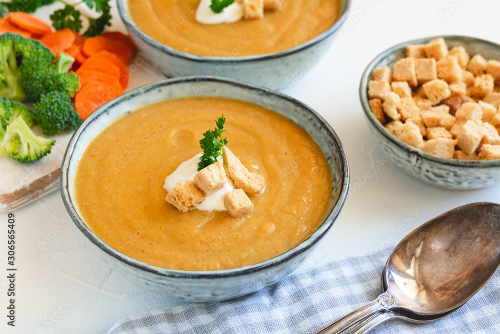 Cream vegetable soup broccoli, carrot, cauliflower with croutons. Vegetarian healthy food on light background Cream vegetable soup broccoli, carrot, cauliflower with croutons. Vegetarian healthy food on light background