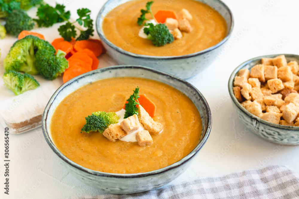 Cream vegetable soup broccoli, carrot, cauliflower with croutons. Vegetarian healthy food on light background Cream vegetable soup broccoli, carrot, cauliflower with croutons. Vegetarian healthy food on light background