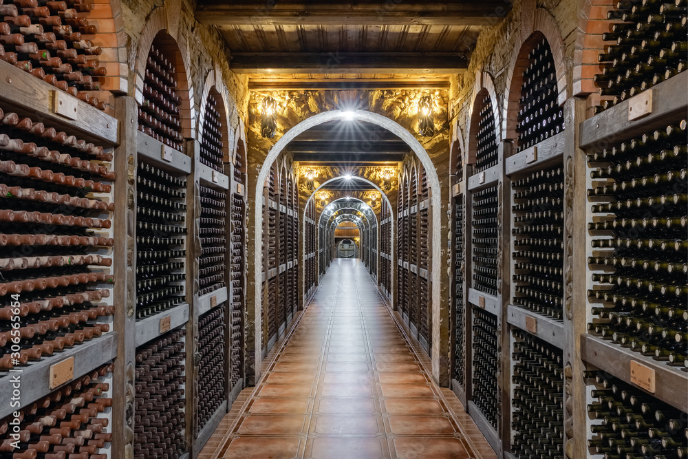 Wine bottles stacked up in underground wine cellar