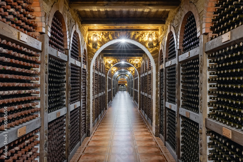 Wine bottles stacked up in underground wine cellar photo