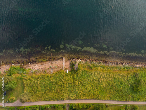 Aerial view straight down of a small beach and wooden bridge at the shoreline of the island Ven in southern Sweden in summer.  photo