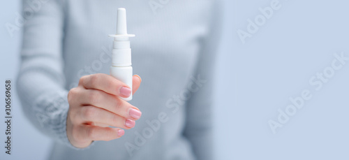 Woman holding nose nasal spray medicine health care on gray light background, space for text