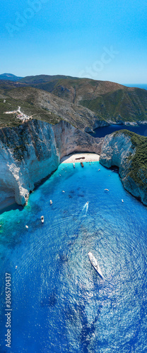 Portrait aerial drone shot of Zakynthos Navagio beach with yachts and cruise ship in Ionian sea in Greece