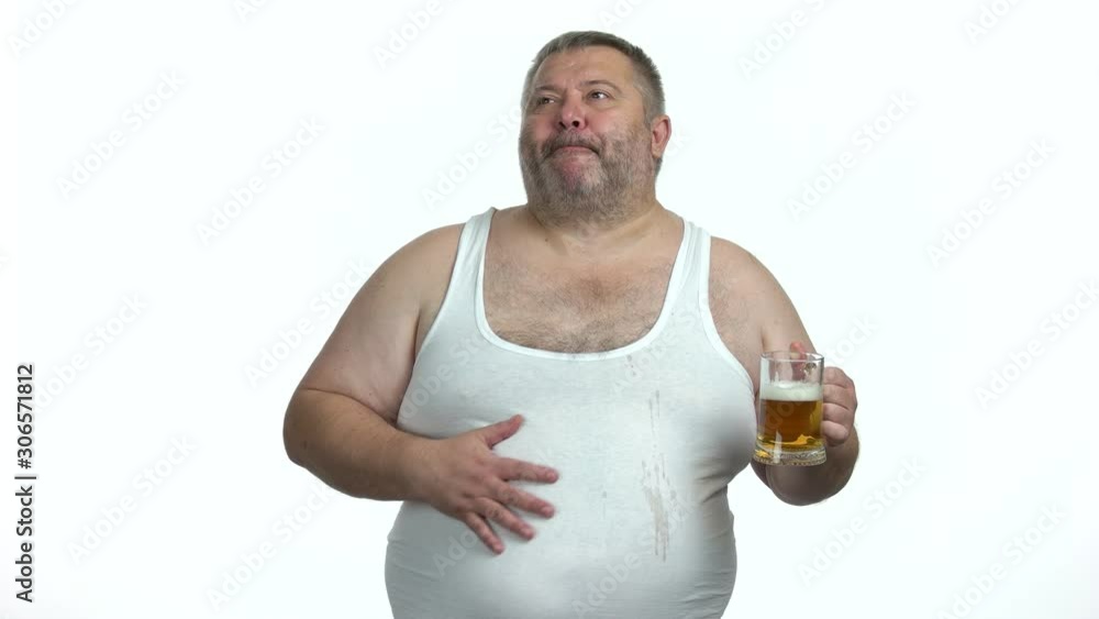 Happy man drinking beer on white background. Obese guy drinking beer with beer belly. Beer and obesity. Happy man drinking beer on white background. Obese guy drinking beer with beer belly. Beer and obesity.